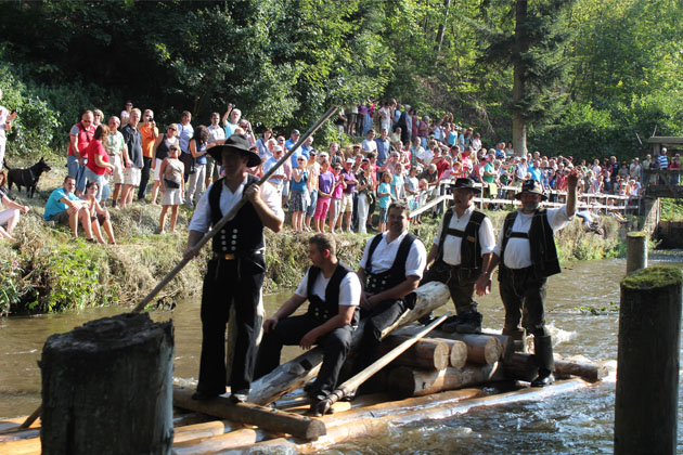 Flößerfest an der Monhardter Wasserstube in Altensteig-Monhardt: Die Flößer fahren mit einem Floß durch die Wassergasse der Wasserstube