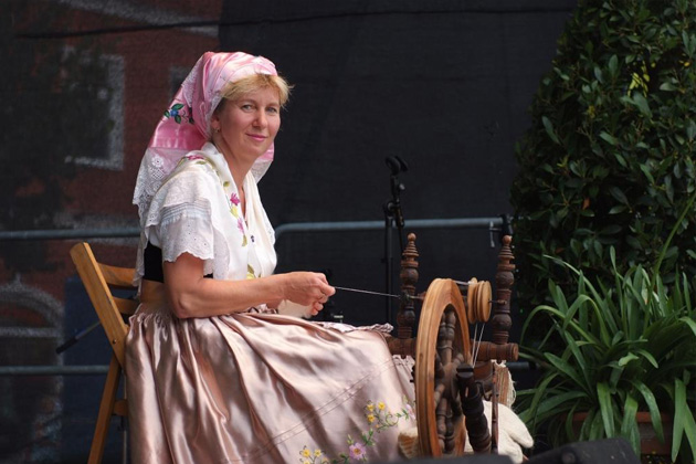 Eine Spinnerin in der traditionellen sorbischen Tracht auf dem Spreewälder Gurkentag in Golßen